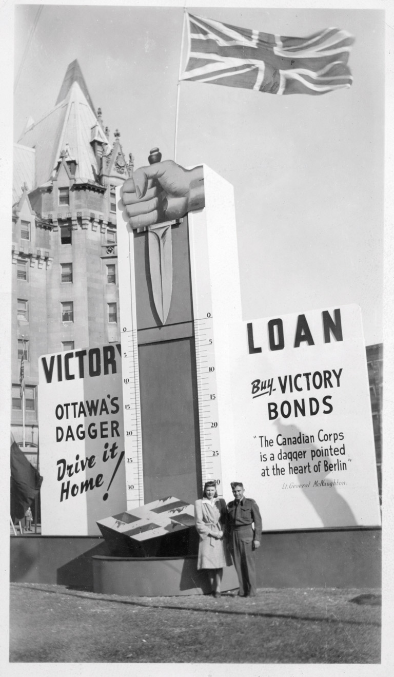 Photograph of Helen Scherempp Hochstein and Wilfred Schrempp in front of Ottawa's Dagger victory loan thermometer. 