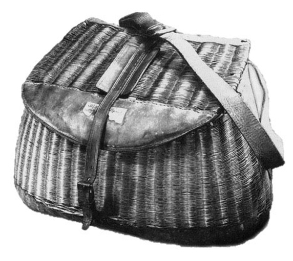 A grey scale image of a basket with a shoulder strap.