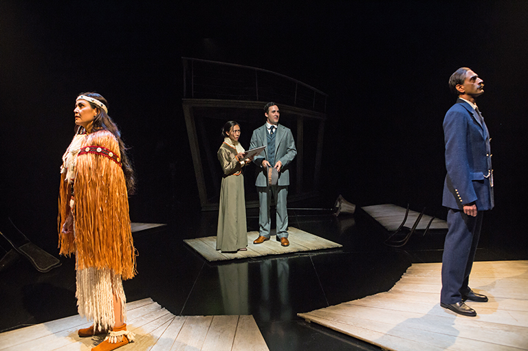 This image shows four people including one couple standing on a stage looking away from each other.